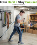 Man using a resistance band with Built Like A Tank Wall Mounted Workout Gear Organizer Rack With Eight Heavy Duty Hooks.