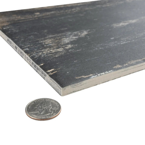 Close-up of Retro Nero Porcelain Floor And Wall Tile 8.25 X 23.5 Inches showing texture and thickness next to a coin for scale.