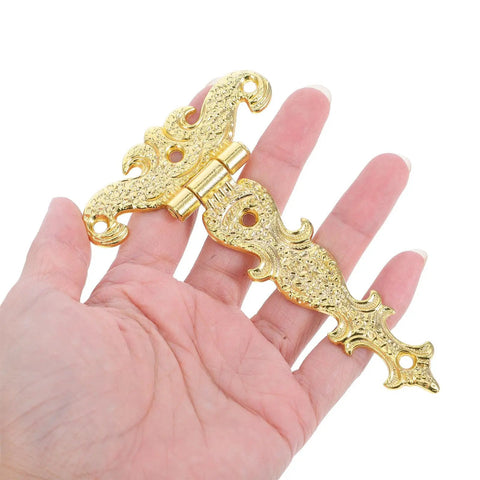 Hand holding Retro Vibe Door Hinge Set 2 Pack Zinc Alloy Hardware With Smooth Operation And Golden Finish For Wooden Boxes And Cabinets
