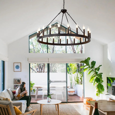 Black Wagon Wheel Chandelier 40 Inch With 20 Lights hanging in modern living room with high ceilings, creating cozy glow.