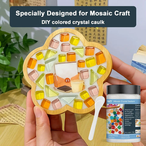 Hand holding glass mosaic art with jar of white quick dry crystal tile grout ready to use caulking agent for crafts