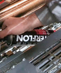 Person applying Dry Film Lubricant Lube TF For Industrial Machinery And Moving Parts Long Lasting Non Staining Wear Reduction Anti Corrosive Aerosol Lubricant For Maintenance And Lubrication Multipurpose Industrial Grade Solution 500ml to machine gears.