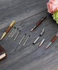 Bolt Action Pen Kit Set With Mandrel For Woodturning 9 Pcs DIY Ballpoint Pen Making Kit In Silver Gold And Gun Gray With Rosewood Bushings And Black Refills Go To DIY Gift For Men displayed on wooden surface.