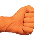 Orange nitrile glove with raised diamond grip on a gloved hand; close-up