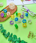 Super Handy Eighty Pack Of Eight Millimeter Numbered Leg Bands In Eight Vibrant Colors Perfect For Identifying Your Quail Pigeon Finch Dove Lovebird And Other Small Birds With Easy Clip On Design displayed on green background with accessories