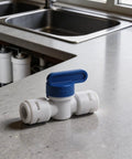 5 Piece 3/8 Inch Quick Connect Shut Off Ball Valve Push Fit Polypropylene Connector For Water Filter Lines on a kitchen counter.