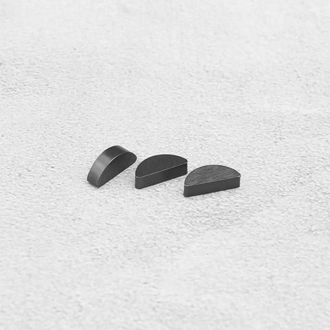 Three metal semi-circular pieces displayed on a textured surface, part of Ten Pack 15x4x6 Mm Woodruff Keys For Lawn Mower Spare Parts.
