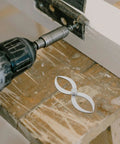 Badass Stainless Steel Double Ended Woodturning Calipers for Precise Internal and External Measurements beside a power drill on a workbench.