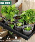 Person holding Seed Starter Kit With 10 1020 Seed Trays And 2 Seedling Heat Mats for faster germination in indoor gardens.