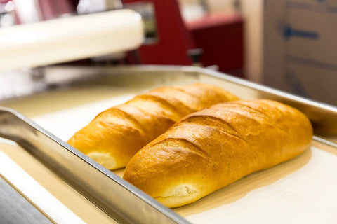 Freshly baked bread on a tray, ideal for use with One Gallon Baking Soda For Cooking And Baking Cleaning And More Pure Sodium Bicarbonate With Nothing Added
