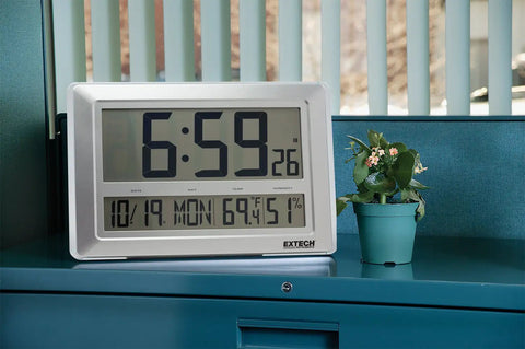 Radio Controlled Wall Clock With Hygro Thermometer And Calendar, 4.3 Inch High Contrast LCD displaying time and date on desk.