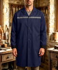 Mens Heavy Duty Mechanic Lab Coat With Reflective Safety Strips Breathable Navy Workshop Uniform worn by a man standing in a workshop.