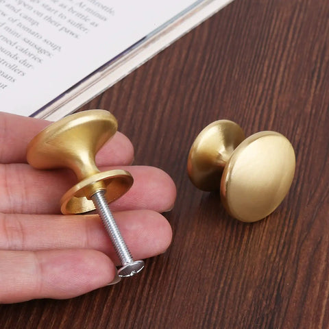Person holding Brass Cabinet Knobs Set 30 Pack 1 Inch Gold Drawer Pulls For Dresser Kitchen Cabinets With Durable Zinc Alloy Construction and Smooth Round Disc Design