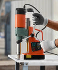 Hardcore 1450W Magnetic Core Drill 2 Inch Hole Capacity 2922 Pound Holding Force Variable Speed Copper Motor Pro Grade Machine For Steel Plates Includes Six Pilot Bits Total Slick Beast Setup with operator adjusting settings.