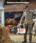 Man using 61 inch Manure Fork with 18 angled tines and fiberglass handle for stable cleanup with horses in background.