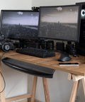Undermount Keyboard Tray With Ergonomic Tilt And Clip Mount installed on a wooden desk below dual monitors for efficient workspace organization.