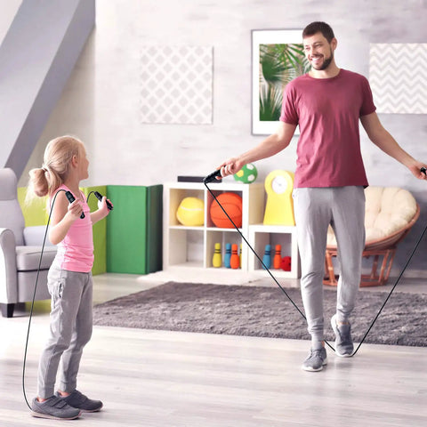 Man and child using Tangle Free Rapid Speed Jump Rope with ball bearings and steel cable in a home gym setting.