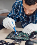 Man using Four Piece Ceramic Screwdriver Set With Non Conductive Slotted Tips And Anti Static Plastic Build For Safe Electronics Work on a circuit board.