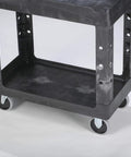 Top Tier Heavy Duty Two Shelf Utility Cart With Durable Structural Foam Lipped Trays And Smooth Glide Handles 500 Lb Capacity close-up of rolling cart wheels and tray.
