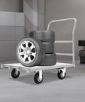 Heavy Duty Platform Truck Cart With Rock Solid Steel Deck And Smooth Roll Casters Built To Shift Two Thousand Pounds Like A Pro, transporting stacked tires in a workshop.