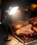 Magnetic Grill Light That Attaches To Any Metal Grill, Rechargeable 360 Degree Rotating Waterproof Work Light illuminating food on a grill.