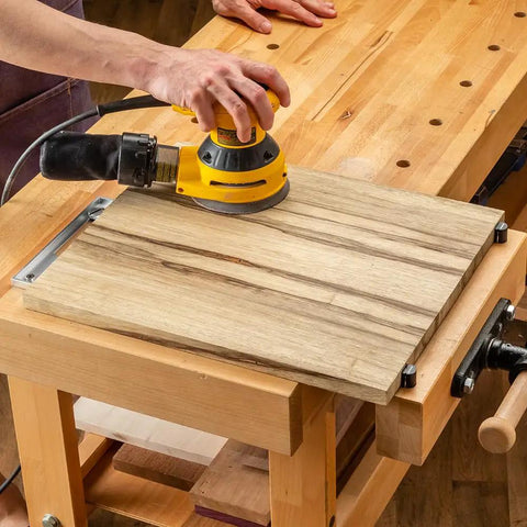 Using a sander on wood secured with 2 Inch Aluminum Round Bench Dogs With Beefy Side Spring For Thin Benchtops And Woodworking Tools.