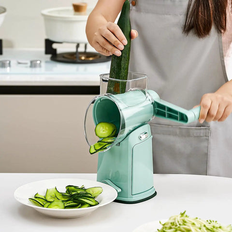 Person using Rotary Cheese Grater Hand Crank 5 In 1 Mandoline Slicer With 5 Stainless Steel Blades to slice cucumber in kitchen.