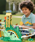 Child playing with Dinosaur Climbing Slide Toy With Racing Track For Toddlers 3 4 5 6 7 8 Light Up Music Themed Car Track Set