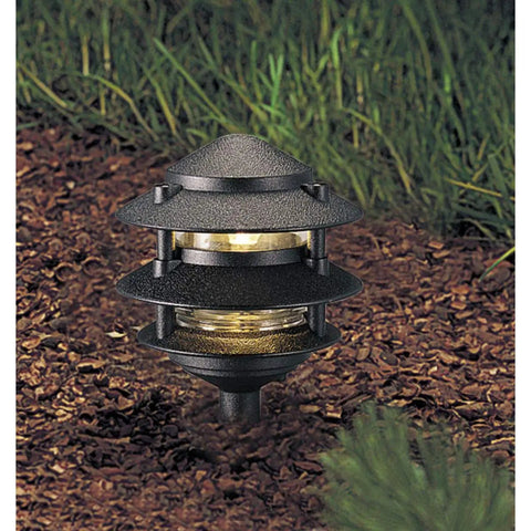 Three Tier Lantern Style Line Voltage Landscape Path Light in black cast aluminum, illuminating garden path with warm glow.