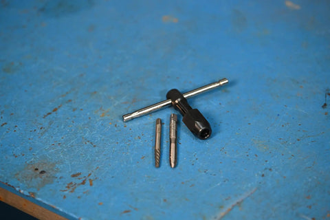 T Handle Tap Wrench 1/4 Inch for Easy Tap Install and Precise Threading shown with taps on a blue workbench surface.
