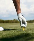 Golfer placing ball on Orange Oversize 3-Pack Golf Tees, 2.4 Inch, Unbreakable Design For Consistent Height And Longer Drives on grassy course