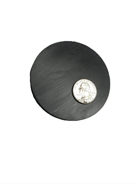 Large 3.025 Inch Diameter Ceramic Ferrite Disk Magnet next to a quarter for scale
