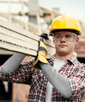 Man wearing cut resistant arm sleeves for work and gardening, protective arm protectors for men with thumb hole, extra large, carrying wood