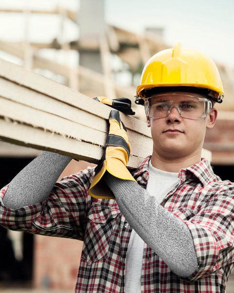 Man wearing cut resistant arm sleeves for work and gardening, protective arm protectors for men with thumb hole, extra large, carrying wood