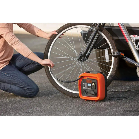 Person using 12V DC Multipurpose Inflator With Digital Gauge, High-Volume For Air Mattresses And Rafts, High-Pressure For Car And Bike Tires, Includes Deflate Function For Quick Cleanup, Dope Portable Auto Accessory on a bicycle tire outdoors.