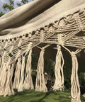 Close-up of crochet fringe on handmade cotton woven hammock chair with rope swing for indoor outdoor patio boho vibes