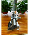 Compact Mini Metal Lathe For Benchtop Use With 3 Jaw Chuck And Tailstock on a wooden table with plants in background.