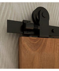 Close-up of black T style roller on Sliding Barn Door Hardware Kit 4Ft To 20Ft Rail System with wooden door