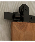 Close-up of Heavy Duty Sliding Barn Door Hardware Kit With Industrial Track System And Smooth Glide T Style Roller Hanger installed on wood.