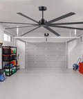 Badass 84 Inch Industrial Ceiling Fan With Reversible DC Motor And Eight Robust Blades Delivers Six Speed Remote Control Hella Quiet Airflow For Massive Garages And Shops In Matte Black in a spacious garage.