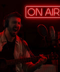On Air Neon Sign LED Light For Streamers And Gamers Red Lit On Air Sign In Recording Studio With Guitar Player