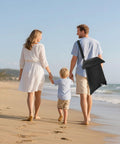 Family walking on beach carrying 2-In-1 Sand Free Beach Blanket And Tent, 79 By 83 Inch Waterproof Picnic Blanket