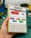 Hand holding 8400Pcs SMD Resistor Kit From 0 Ohm To 1M Ohm 1% Tolerance In 0805 1206 0603 0402 0201 Sizes box