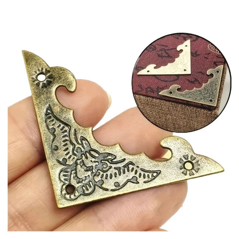 Close-up of 200-Piece Iron Corner Brackets Set In Antique Bronze, 40mm showing vintage design detailing for boxes and crafts