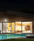 House at night with Hyper Bright LED Motion Activated Security Flood Light illuminating the patio and poolside area.
