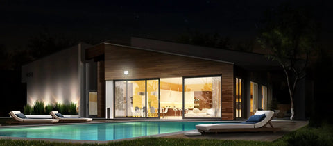 House at night with Hyper Bright LED Motion Activated Security Flood Light illuminating the patio and poolside area.