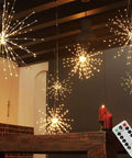 Dope 200 LED Hanging Sphere Lights with remote control on a dark ceiling indoors, warm white ambiance.