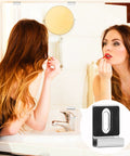 A woman applying lipstick in front of a bathroom mirror showcasing Tough Built Metal Mirror Holder Kit J Type Hanger Clips.