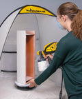 Woman using a spray gun inside a tent with a Revolving Paint Spray Turntable With 11 Inch Round Platform For Spray Painting Projects And Crafting Smooth 360 Degree Rotation For Accessing Every Angle On Miniatures Lamps Bird Houses Models And More.