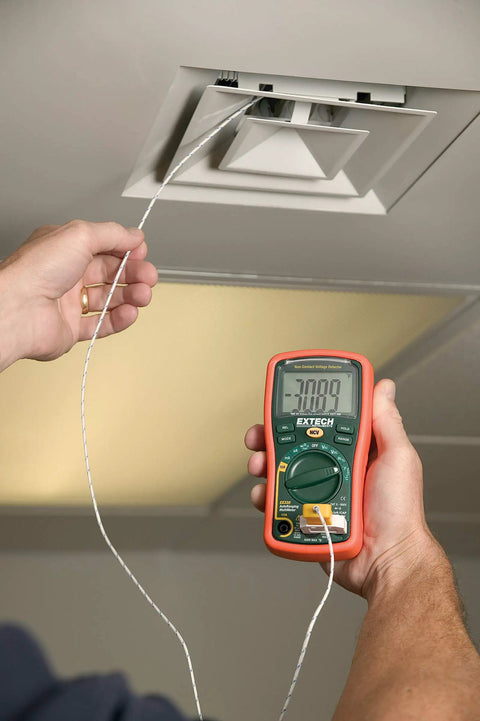 Person using Autoranging Mini Multimeter With Built In Non Contact Voltage Detector Handy Tool For Diy And Pros to check ceiling vent.